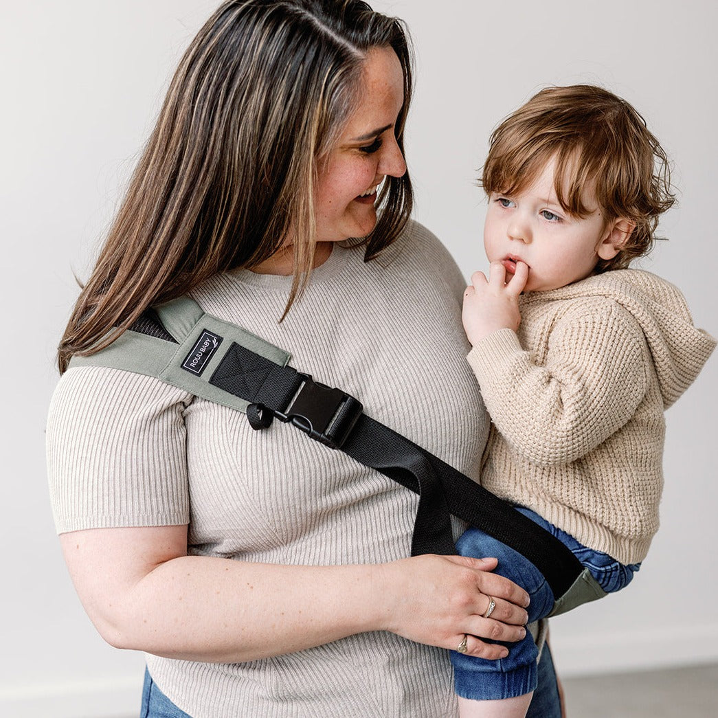 Side view of the Olive Rouu Baby II hip carrier worn on the hip