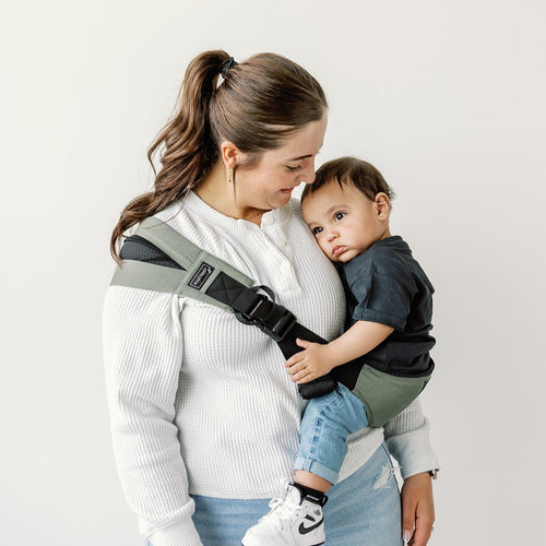 Parent carrying toddler in the Olive Rouu Baby II hip carrier